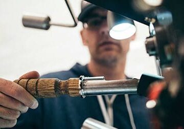 A man is holding a drill with a light on it.