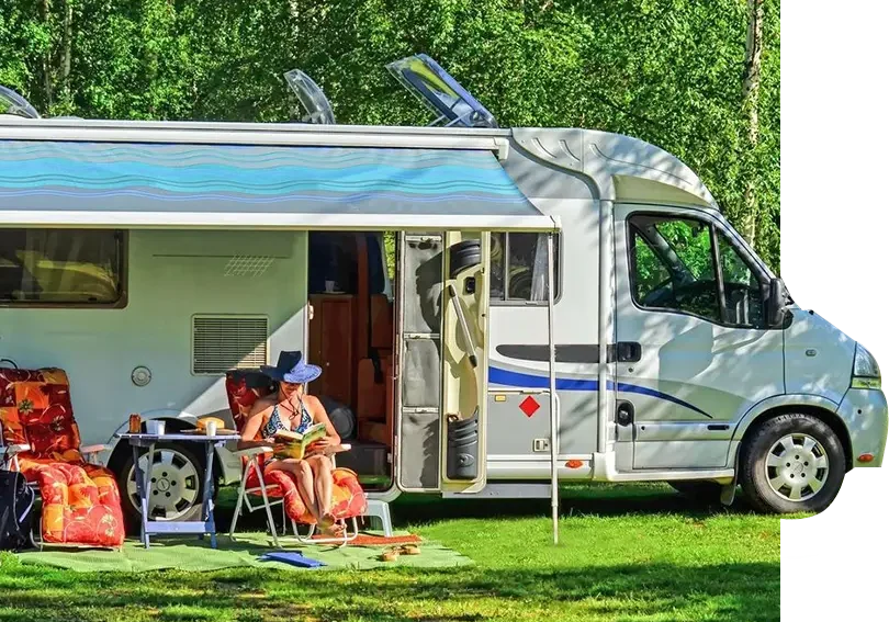 A couple of people sitting on chairs in front of an rv.