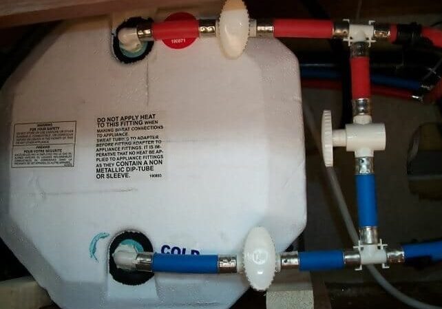 A water heater with two valves and pipes.